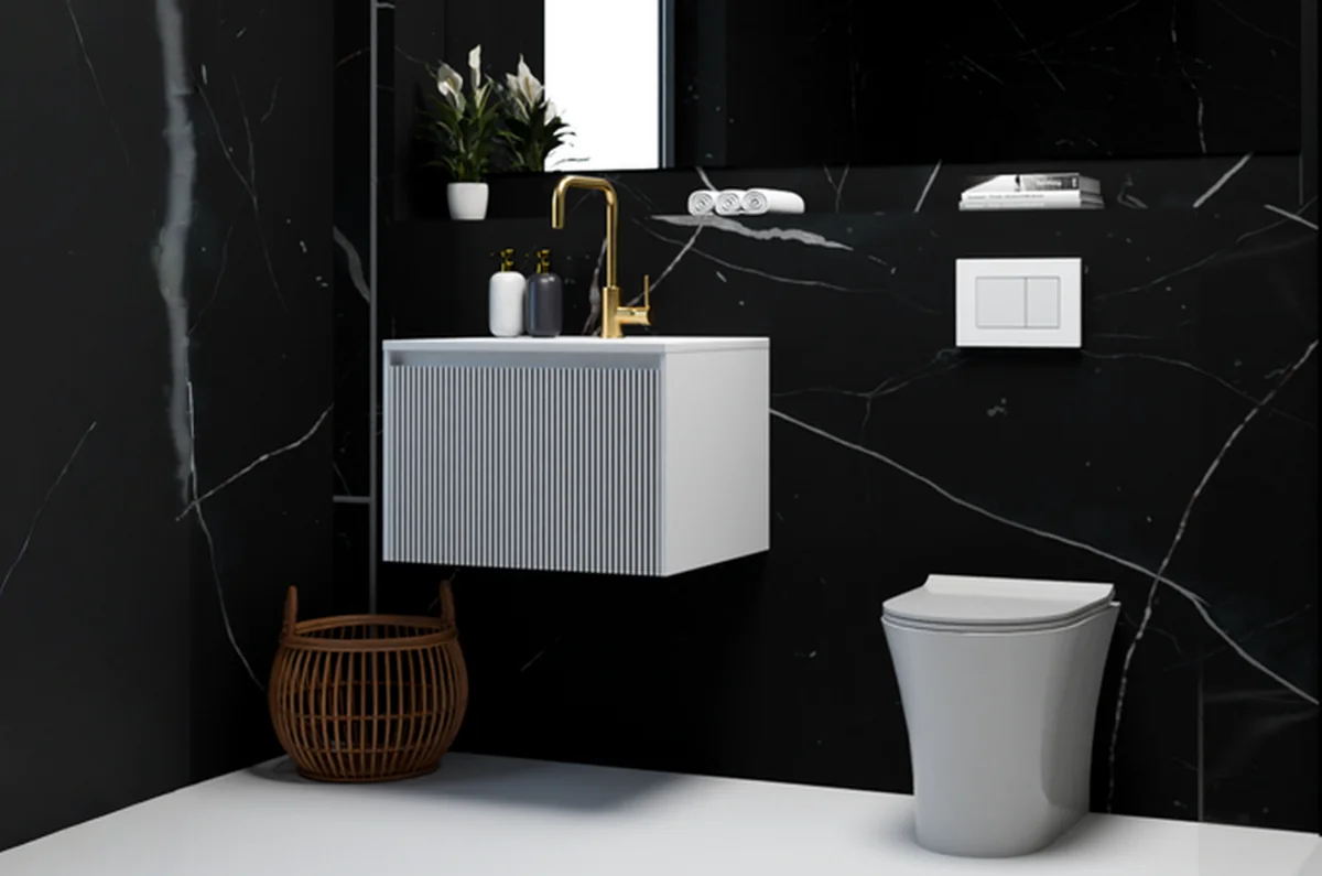 Contemporary bathroom featuring a sleek white wall-hung vanity unit and gold faucet, set against black marble walls. The design highlights the use of high-quality materials, showcasing the best material for bathroom fixtures and finishes